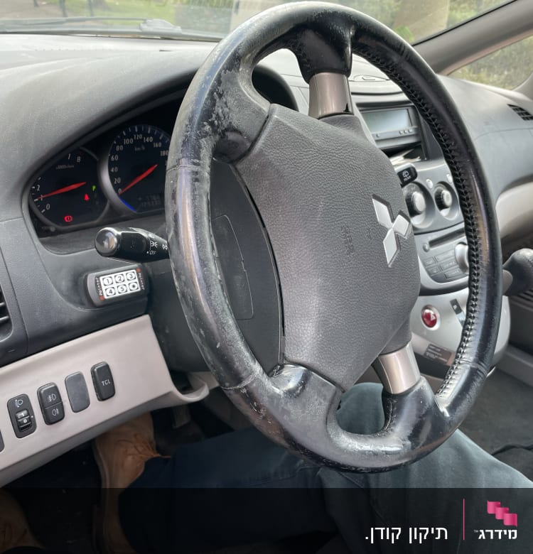 הגה רכב עם לוח מחוונים ומתגים